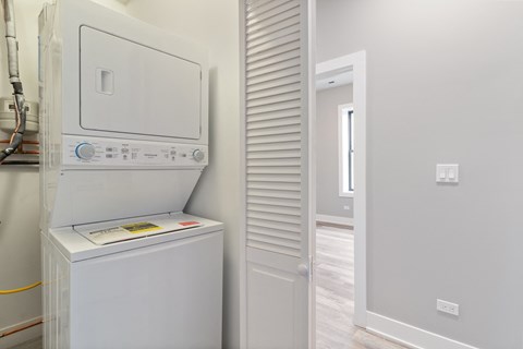 a laundry room with a washer and dryer and a door to a bathroom