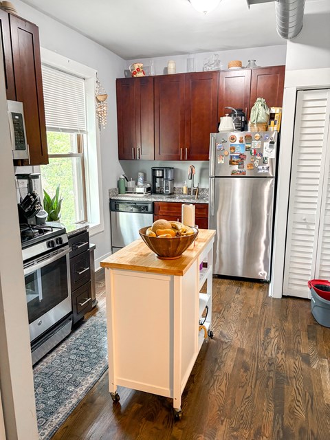 A kitchen with a refrigerator, stove, and island.