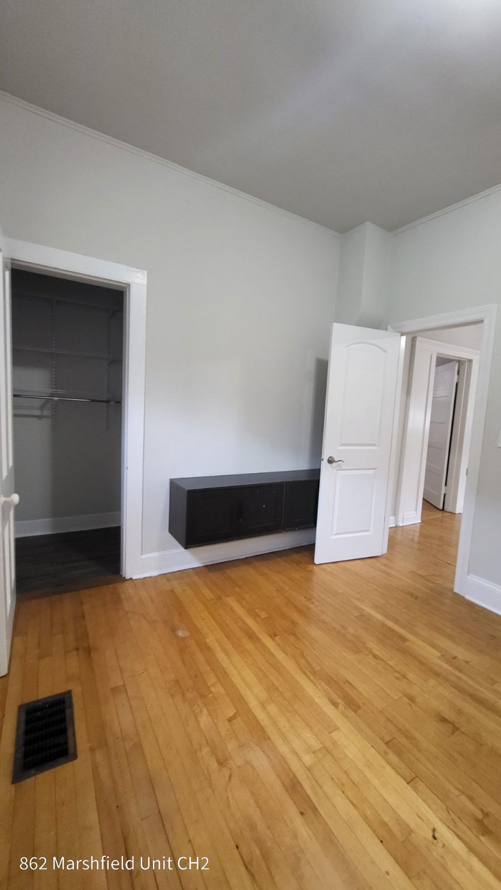 A room with a fireplace and wood flooring.