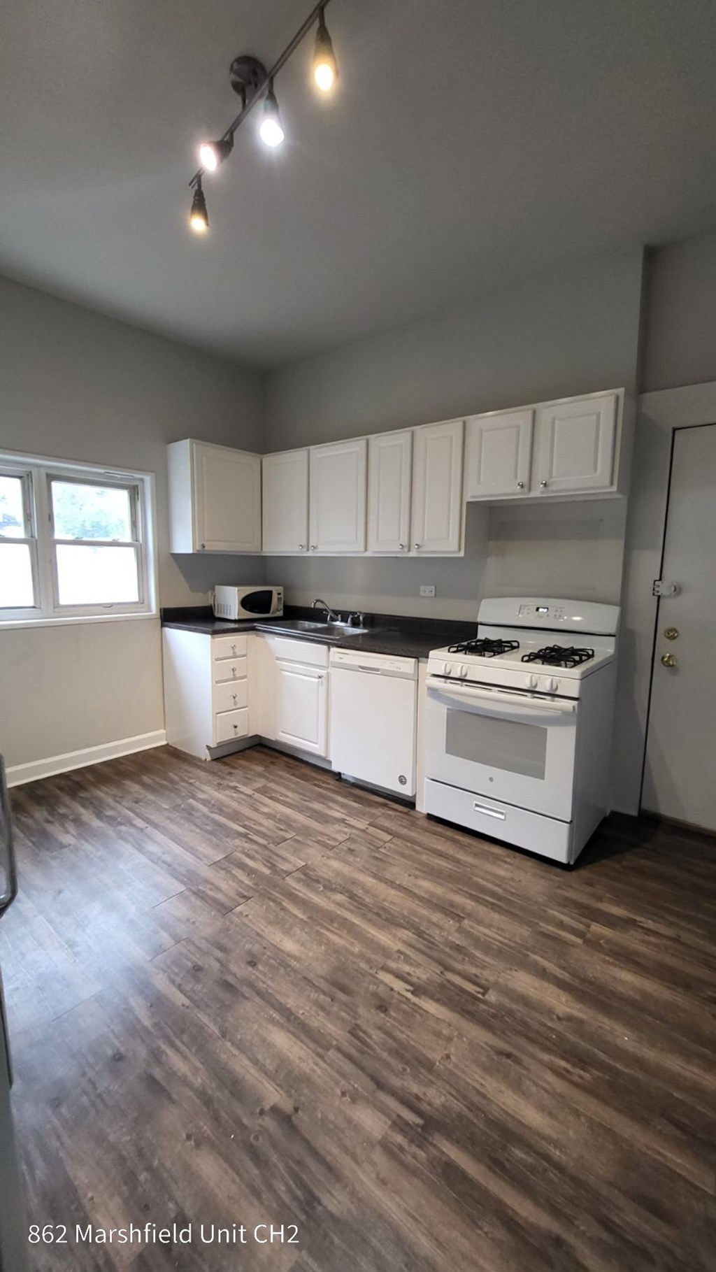 A kitchen with white appliances and cabinets.
