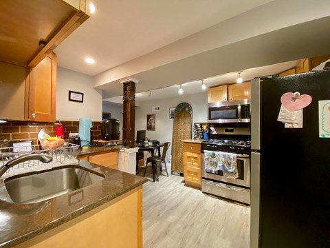 A kitchen with a black fridge and a stove top oven.