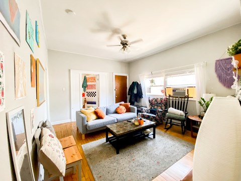 A living room with a couch, chairs, and a coffee table.