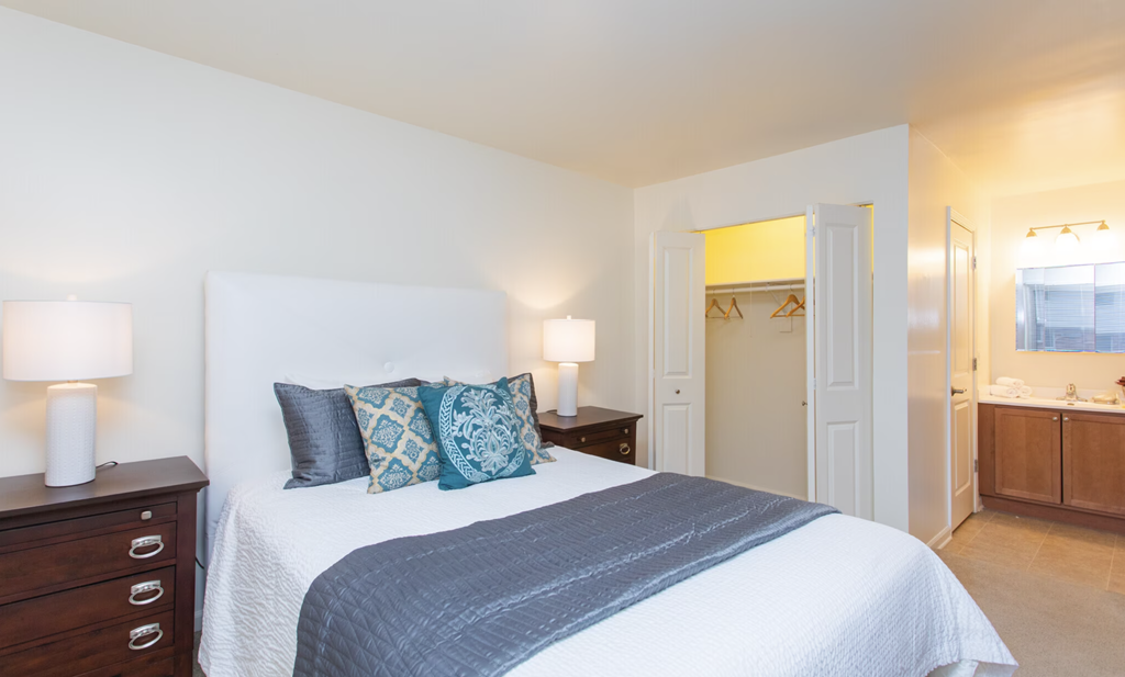 a bedroom with a bed and a bathroom with a sink