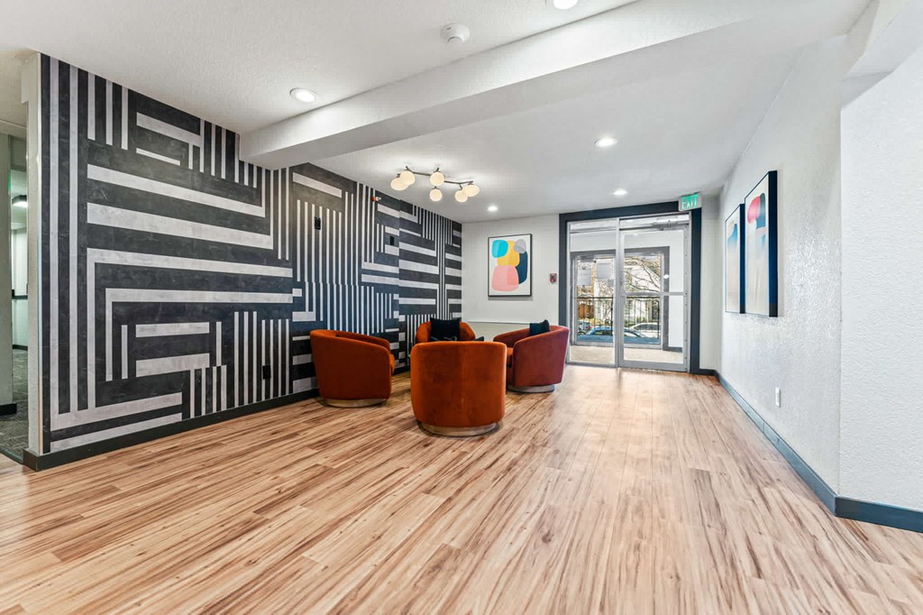 the lobby of a building with chairs and a wall with a graphic design
