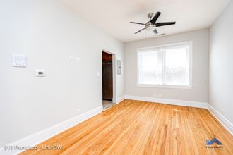 a bedroom with hardwood floors and a ceiling fan