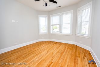 an empty room with hardwood floors and a ceiling fan