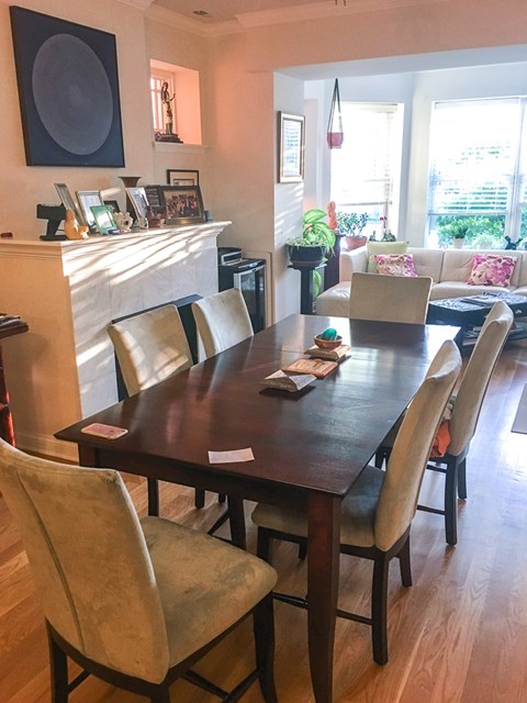 A dining room with a wooden table and chairs.