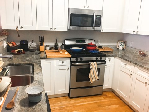 A kitchen with a stove top oven and a microwave above it.