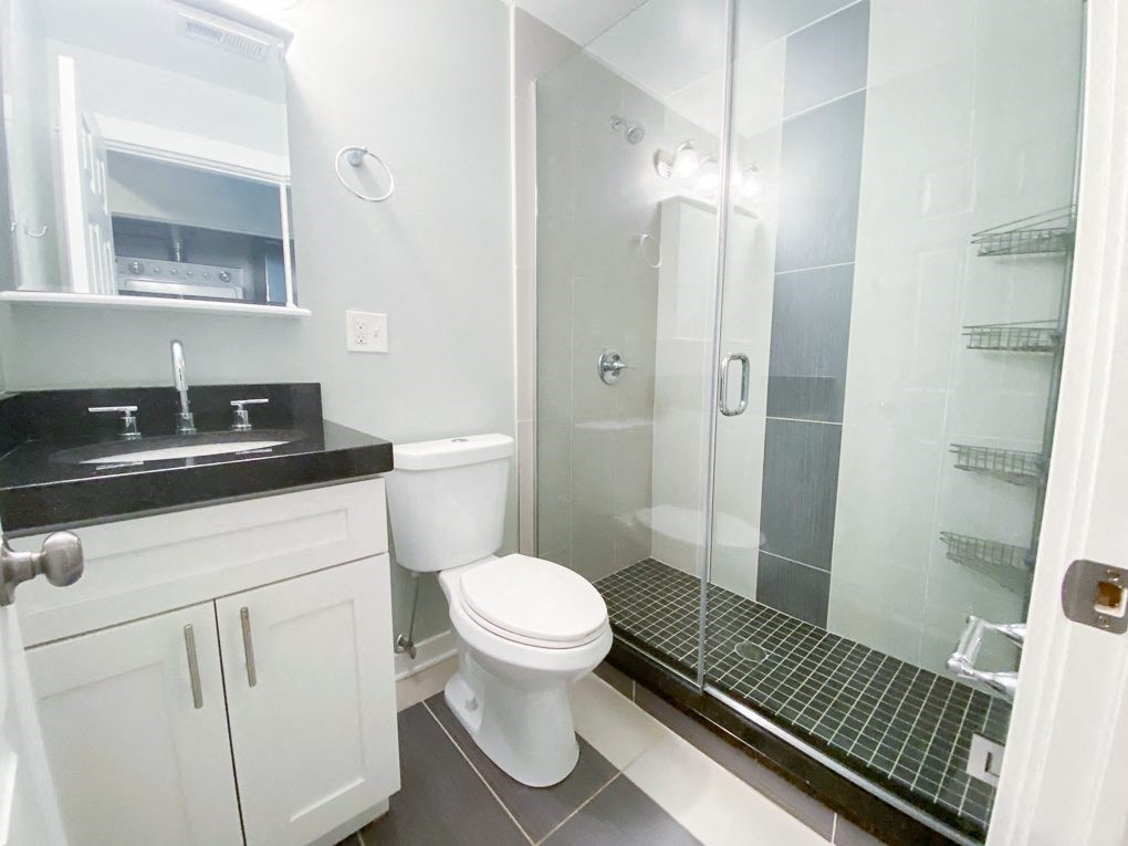 a bathroom with a shower and a sink and a toilet