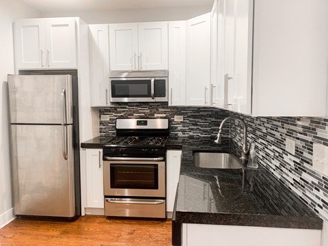 a kitchen with granite counter tops and stainless steel appliances
