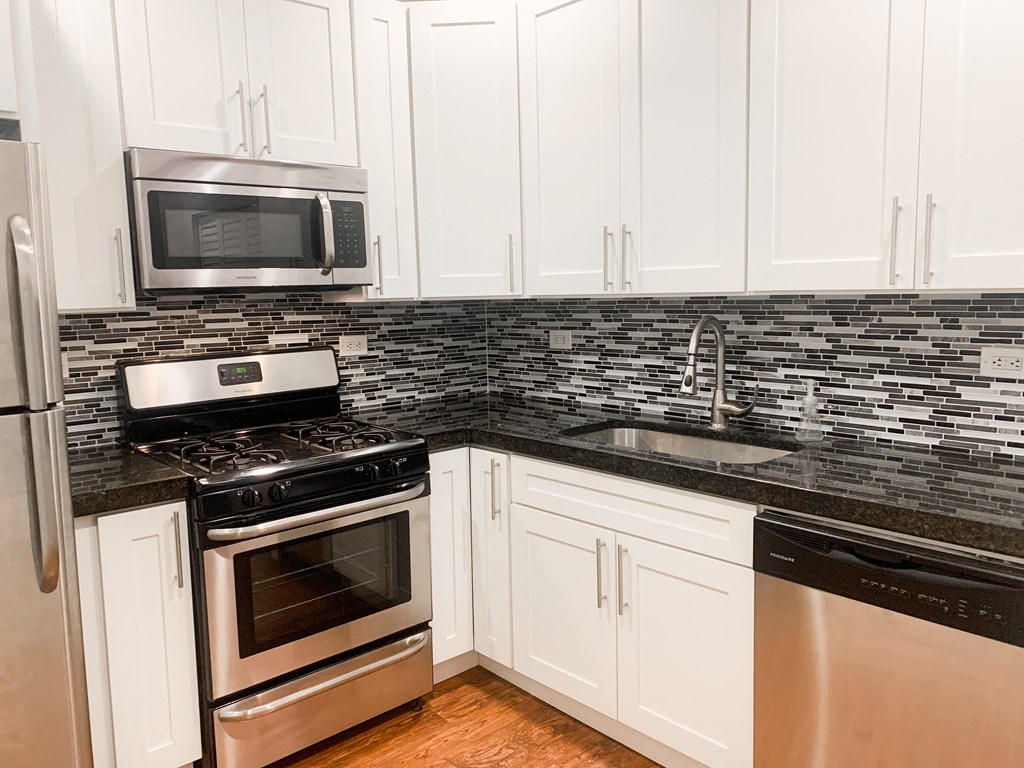 a kitchen with stainless steel appliances and white cabinets