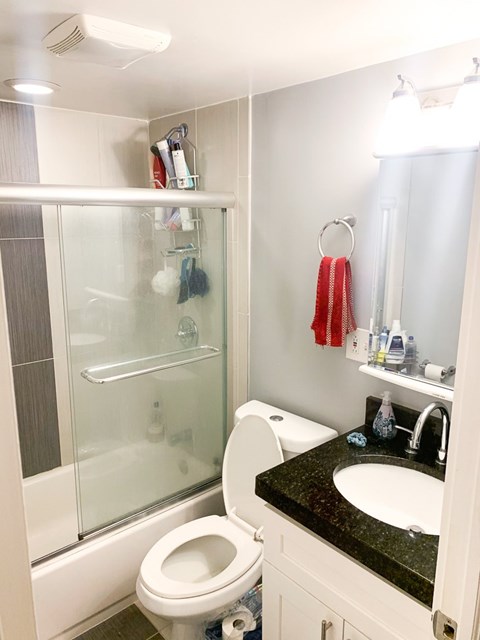 A white toilet sits in a bathroom next to a sink.