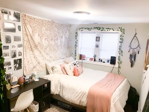 A bedroom with a bed, desk, and chair.