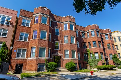 A red brick building with a black gate in front.
