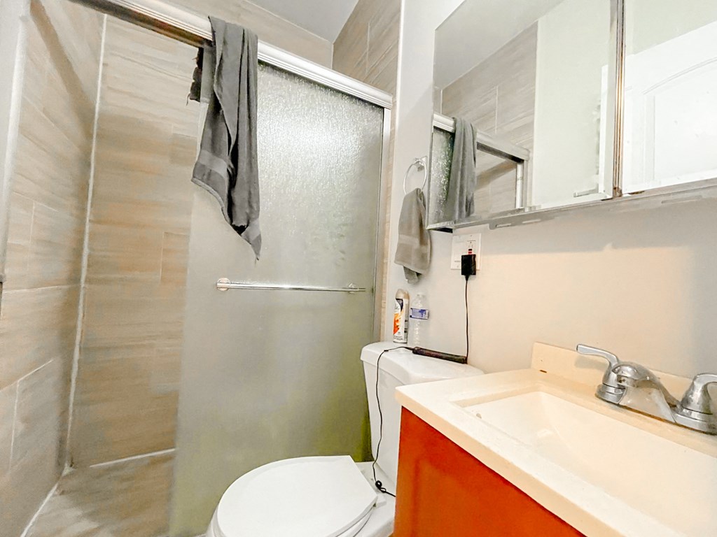 a small bathroom with a shower toilet and sink