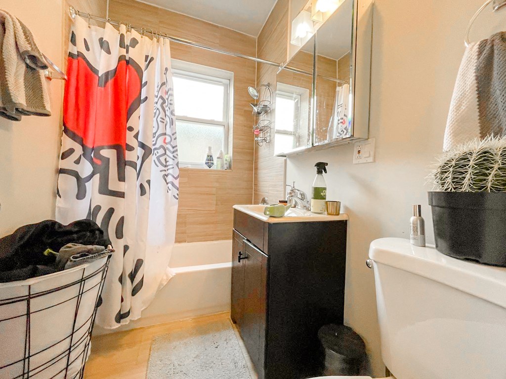a bathroom with a shower curtain and a sink and a toilet
