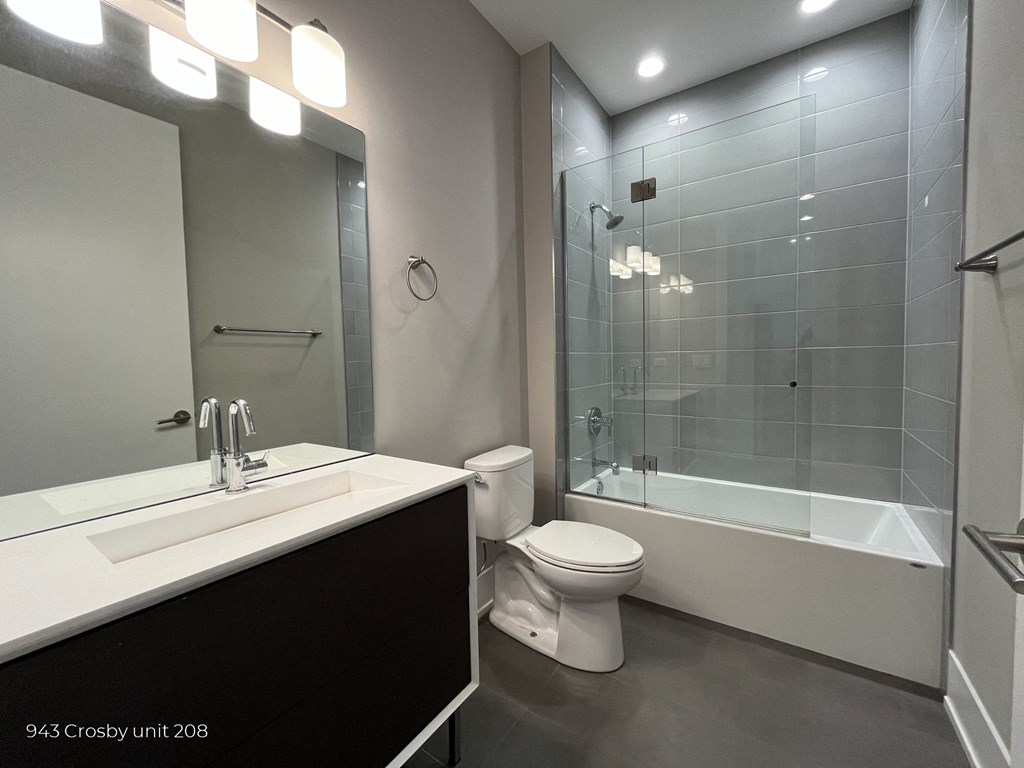 a bathroom with a toilet and a shower and a sink