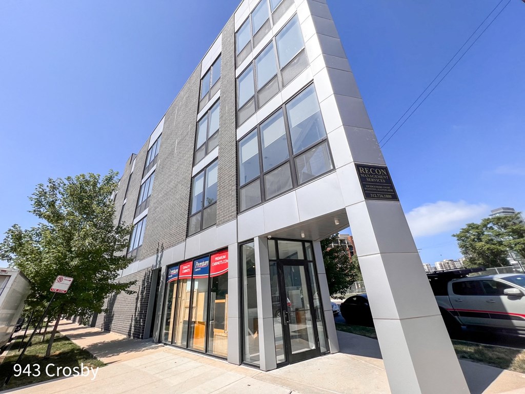 a tall building with a glass door and a sign on the side of the building that says
