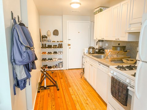 A kitchen with a white stove and wooden floors.