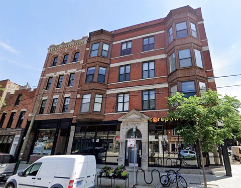 a large brick building with a van parked in front of it