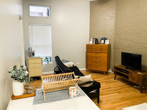 A living room with a black chair and a wooden cabinet.