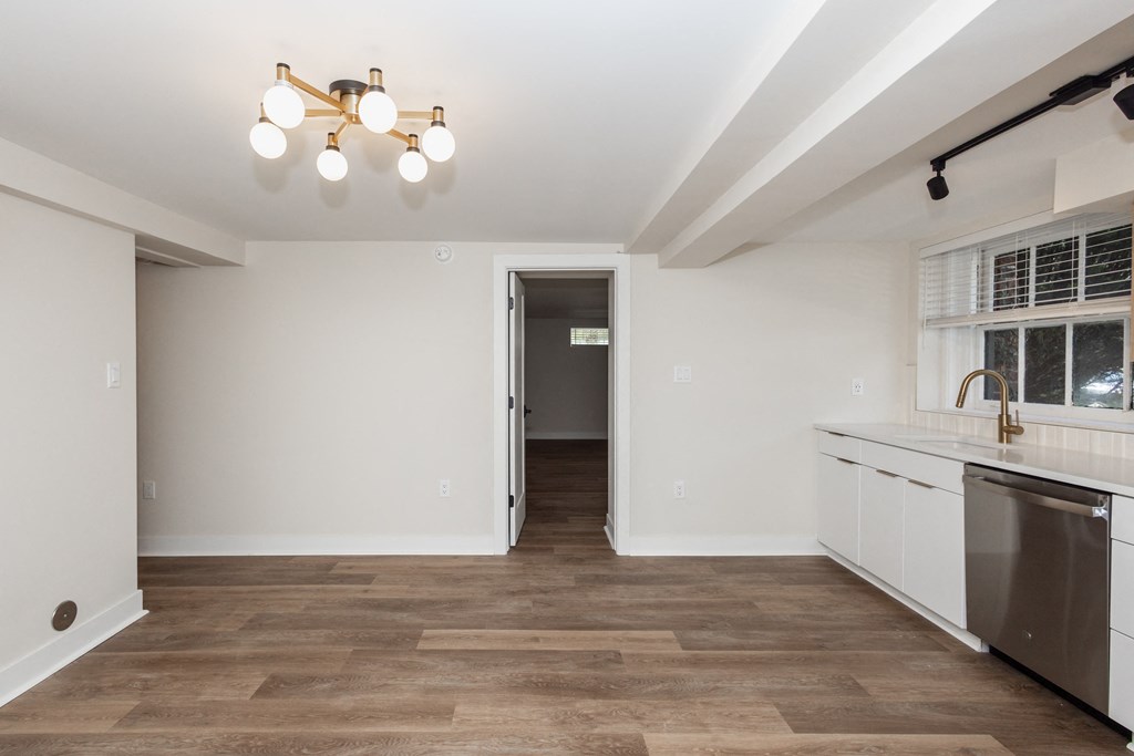 a renovated kitchen with white cabinets and a stainless steel dishwasher