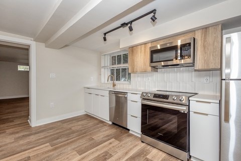 a kitchen with white cabinets and stainless steel appliances