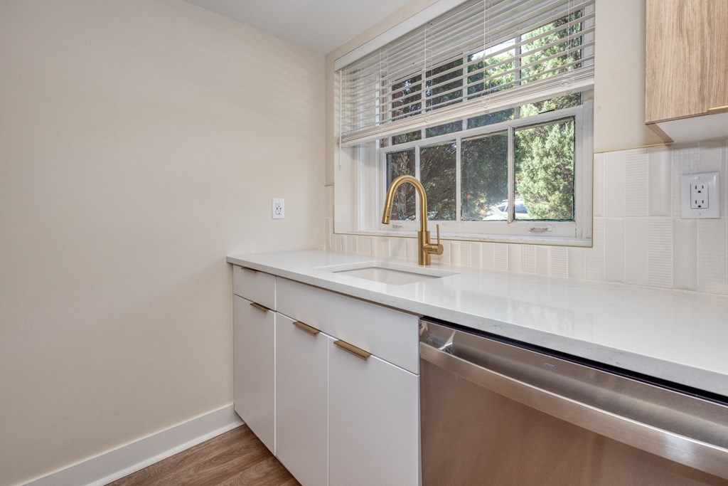 an empty kitchen with a sink and a window