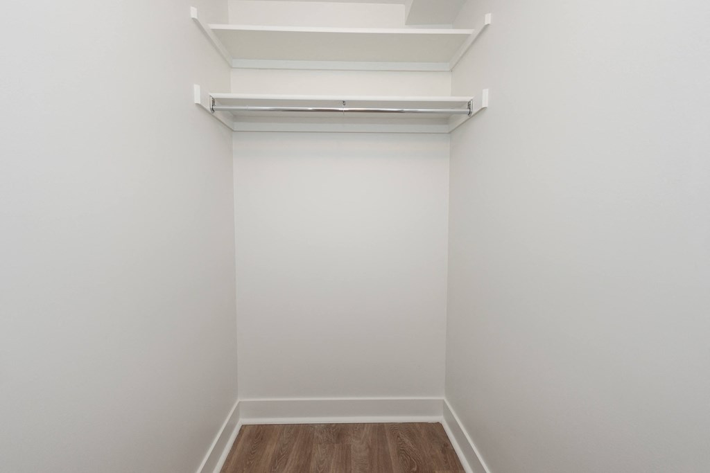 an empty room with white walls and a wood floor