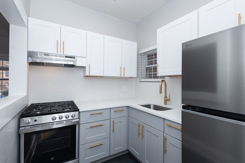 A modern kitchen with a stainless steel refrigerator and a stove with a stainless steel oven.