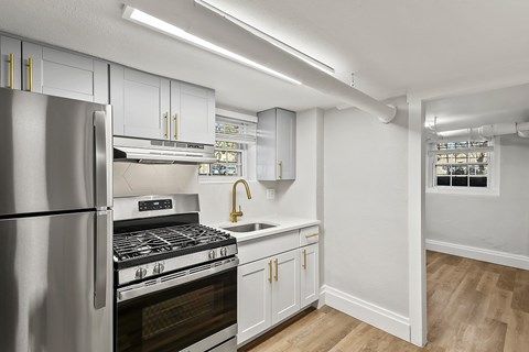 A kitchen with a stainless steel refrigerator and a stove top oven.