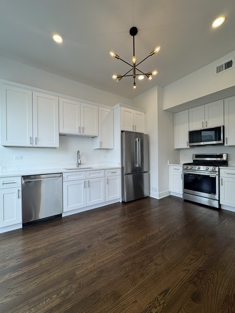 A kitchen with white cabinets and stainless steel appliances.