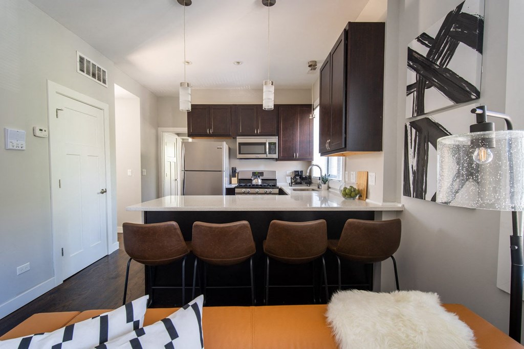 a kitchen and dining room with a counter and chairs