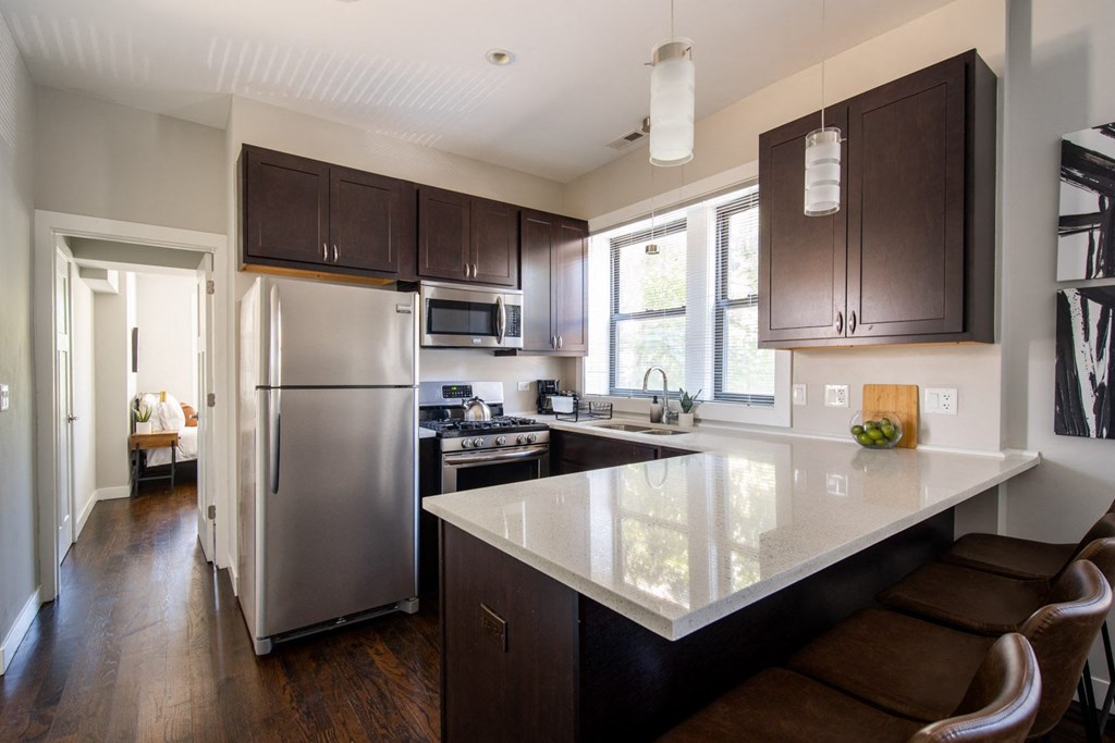 a kitchen with a large island and stainless steel refrigerator