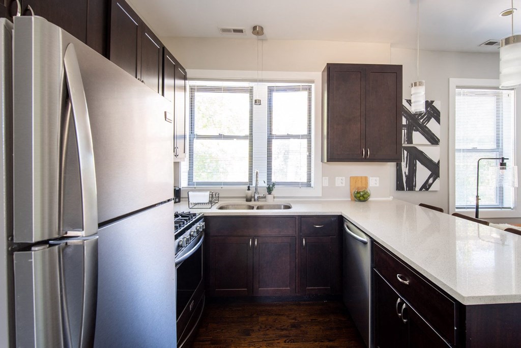 a renovated kitchen with stainless steel appliances and white counter tops