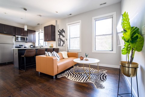 a living room with a leather couch and a zebra rug