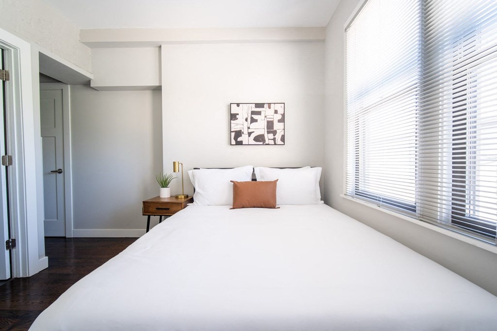 a bedroom with a large white bed and a window