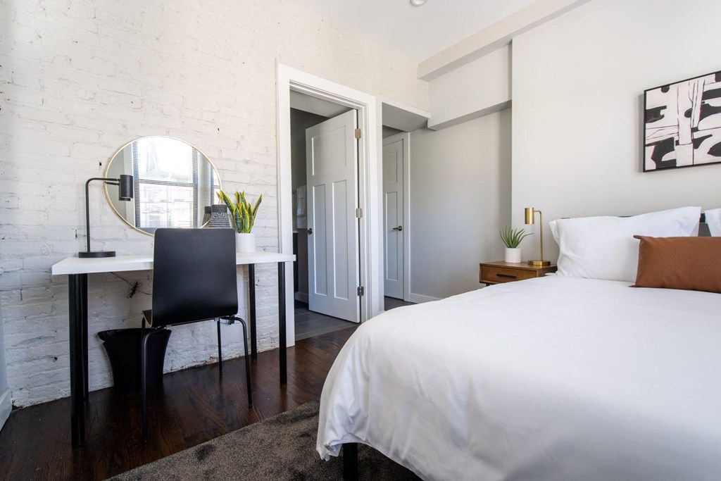 a bedroom with a bed and a desk with a mirror