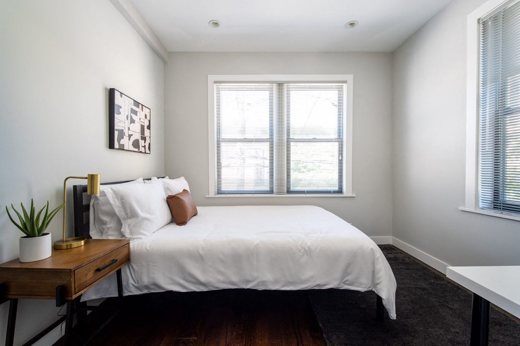 a bedroom with a bed and two windows