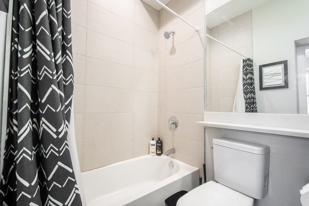 a bathroom with a shower and a toilet and a shower curtain