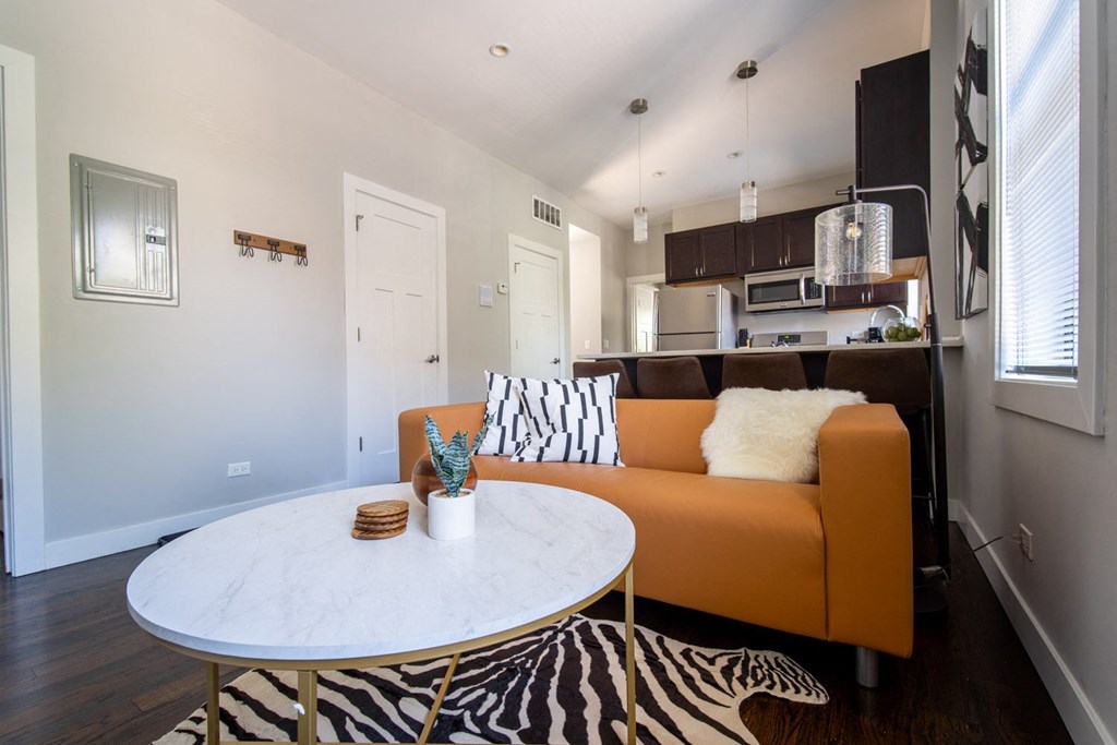 a living room with an orange couch and a white table