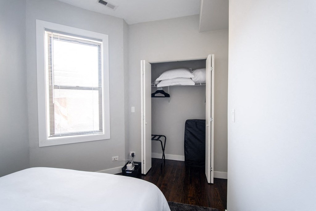 a bedroom with a bed and a closet with a window