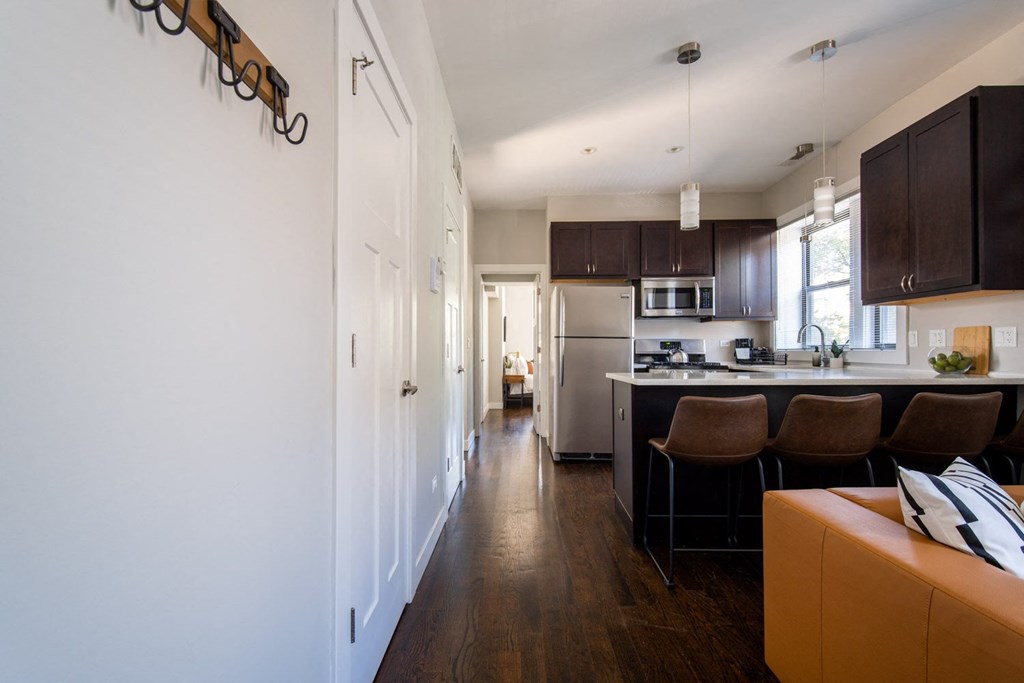 a kitchen and living room with wood floors and white walls