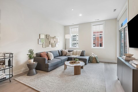 A living room with a grey couch and a coffee table.