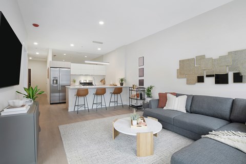 A modern living room with a grey couch and a white coffee table.