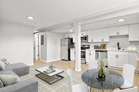 a living room with a glass table and a kitchen