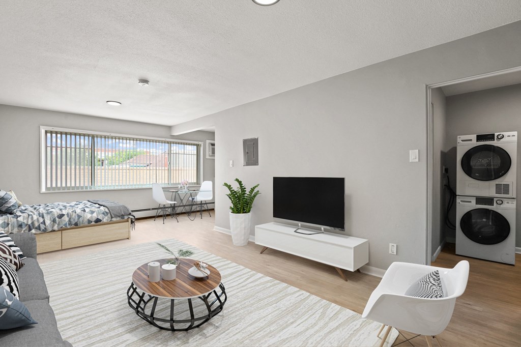 a living room with a couch and a television and a washer and dryer