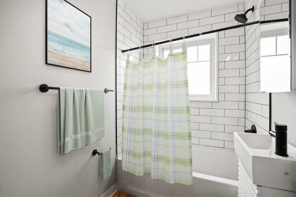 a white bathroom with a shower curtain and a sink