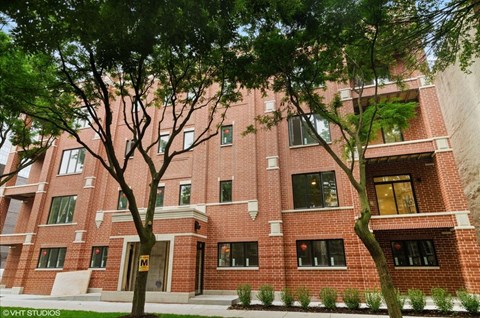 A red brick building with trees in front.