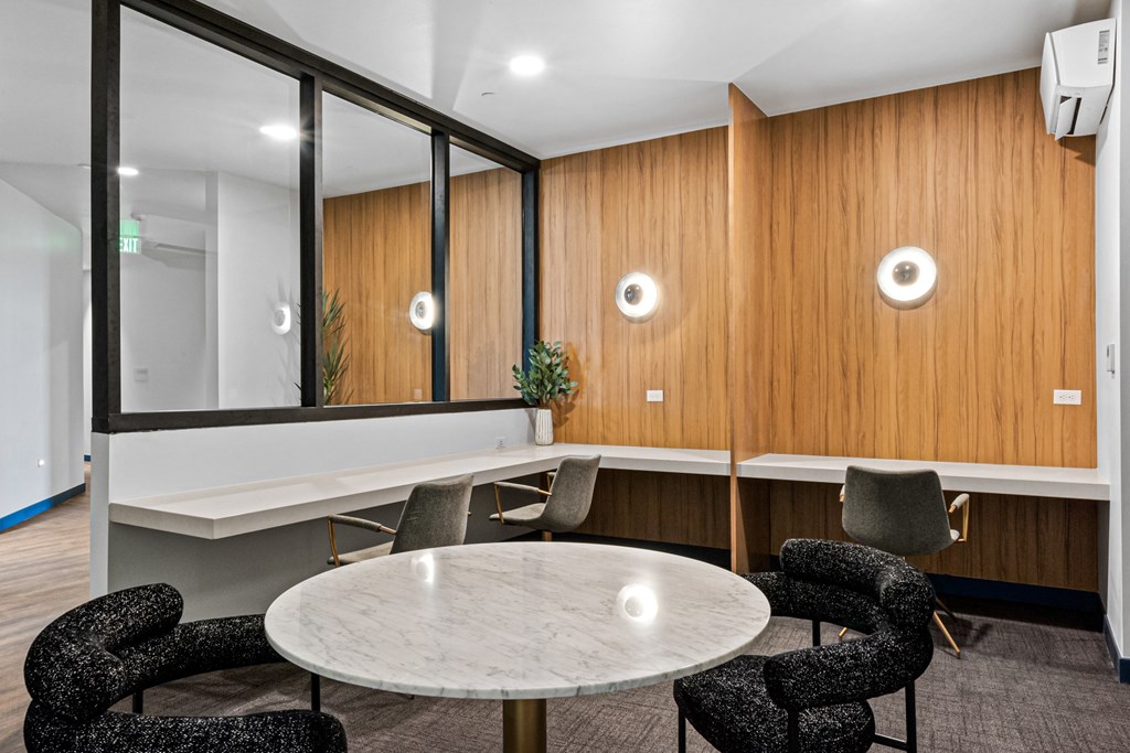 A conference room with a round table and chairs.